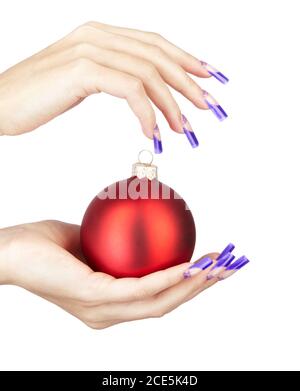 Hände mit blauen französisch falschen Acryl Nägel Maniküre halten rot Weihnachtsball Stockfoto