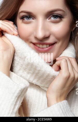 Blonde junge schöne Frau in weißen Wollpullover gekleidet. Stockfoto