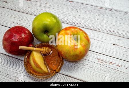 Traditionelle Produkte für die Feier von Rosh Hashanah - Äpfel, Granatapfel, Honig, Waben - auf dem weißen Holzhintergrund Stockfoto