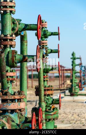 Erdölbrunnen Bohrlochanlage. Handventil mit Handrad an der Durchflussleitung. Ölfeld-Standort. Konzept der Öl- und Gasindustrie. Industr Stockfoto