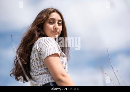 Teenager-Mädchen mit Blick über die Schulter im Freien Stockfoto