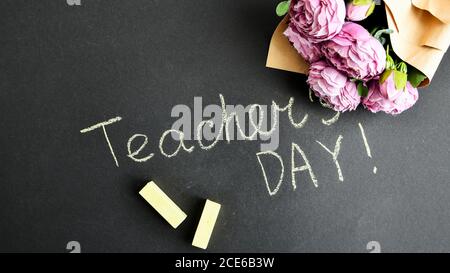 Flache Lay Komposition mit Blumen Pfingstrosen Bouquet und Inschrift LEHRERTAG auf schwarzer Kreidetafel Stockfoto