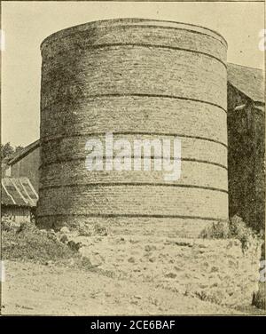 . Scheune Pläne und Nebengebäude . Ziegel Silo wurde von Daniel Brothers von^Middlesex County, CT. Es ist in Abbildung 329 gezeigt, und ist dreißig Fuß hoch, zwanzig Fuß im Durchmesser und builteleven Füße in der Erde. Es hat eine Kapazität von 200 Tonnenund kostet komplette 300 Dollar. Die Mauer wurde acht Incheschick aus geschwelltem Ziegel gebaut, die 3 Dollar pro 1000 und 2 Dollar für die Umkartung kosten. Es brauchte 21,000 Ziegel, um das Silo aufzusetzen. Sechs Hufe von drei-sechzig-Zoll-Flacheisen zwei Zoll breit, mit je einer Lug, wurden rund um das Silo verwendet. Die Fenster für das Auswerfen der Silage sind zwei nach zwei und ein-Halffeet und platziert vier Gebühr Stockfoto