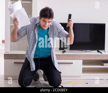 Der Mann, der versucht, defekte Fernseher zu reparieren Stockfoto