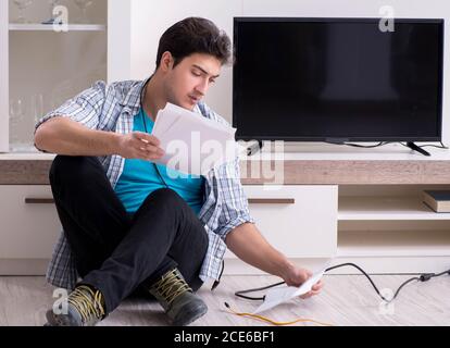 Der Mann, der versucht, defekte Fernseher zu reparieren Stockfoto