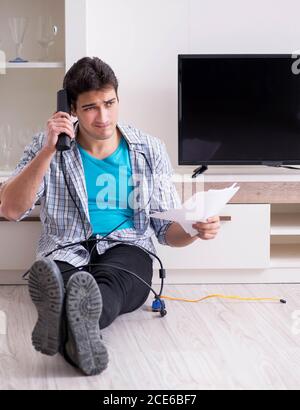 Der Mann, der versucht, defekte Fernseher zu reparieren Stockfoto
