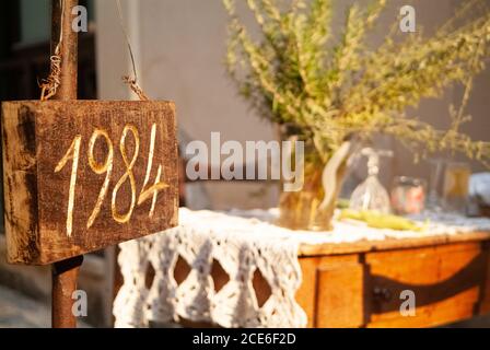 Ein Pfeilschild zeigt das Wort 1984 als Eröffnungsdatum eines Restaurants .Ortigia Stadtgebiet. Syrakus Siracusa, Sizilien Italien, Sommersaison Stockfoto