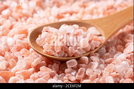 Rosa Steinsalz in einem Holzlöffel in der Nähe erschossen Nach oben Stockfoto
