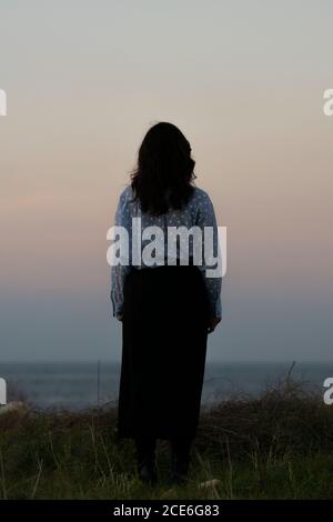 Frau am Strand bei Sonnenuntergang Stockfoto