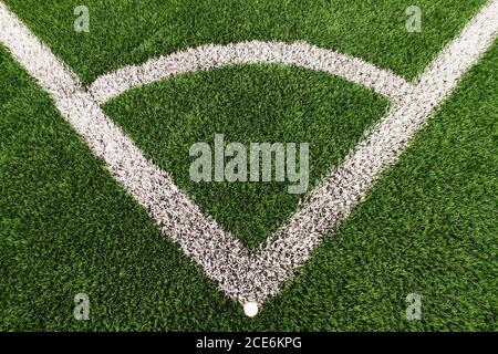 Fußball-Spielplatz Ecke auf Kunstrasen Boden mit lackierten weißen Strichmarkierungen. Gefrästes schwarzes Gummi in BASIC. Stockfoto