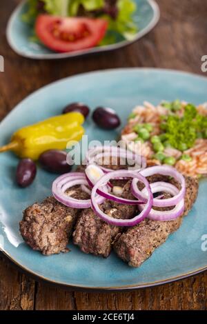 Cevapcici mit Djuvecreis auf Holz Stockfoto