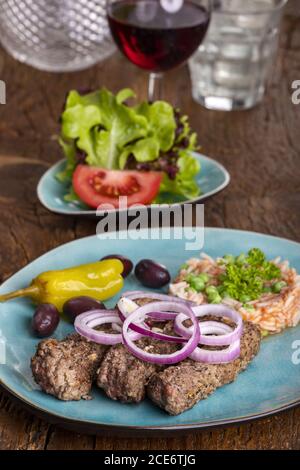 Cevapcici mit Djuvecreis auf Holz Stockfoto