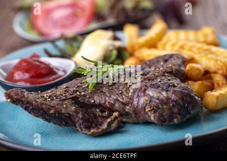 Rosmarin auf einem Steak mit Chips Stockfoto