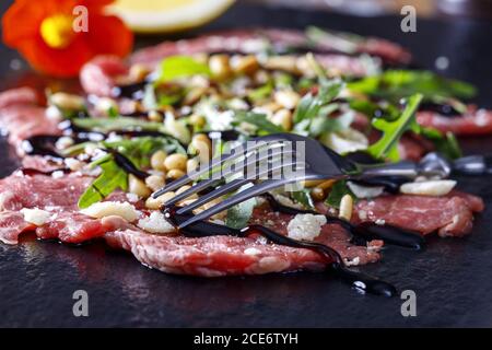 Frischer Carpaccio mit Rucola auf Schiefer Stockfoto