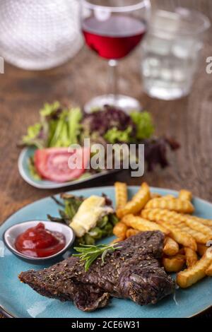 Rosmarin auf einem Steak mit Chips Stockfoto