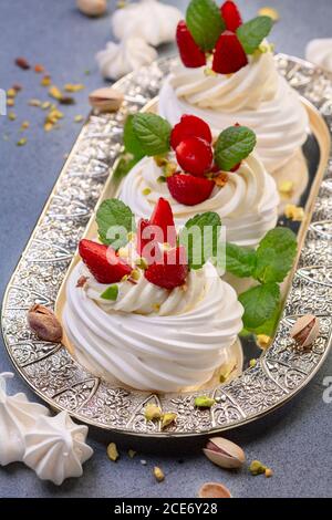 Köstliches Pavlova-Baiser-Dessert mit Erdbeeren und Pistazien. Stockfoto