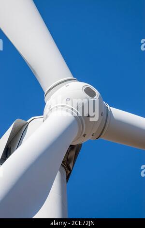 Der Rotorkopf der Windenergieanlage wird vor dem Hintergrund des blauen Himmels ganz in der Nähe angezeigt Stockfoto