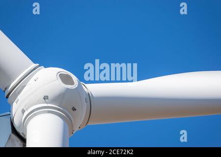 Der Rotorkopf der Windenergieanlage wird vor dem Hintergrund des blauen Himmels ganz in der Nähe angezeigt Stockfoto