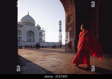 Indien - 9. November 2012: Indische Hündin in traditioneller Kleidung, barfuß auf dem Platz stehend und den atemberaubenden Blick auf Taj Mahal bewundernd Stockfoto