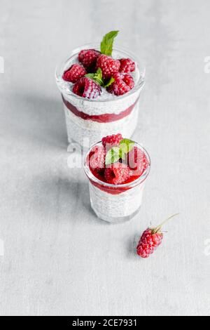 Von oben aus Glas mit leckeren Pudding mit gemacht gefüllt Joghurt Himbeeren Marmelade und Chiasamen Stockfoto