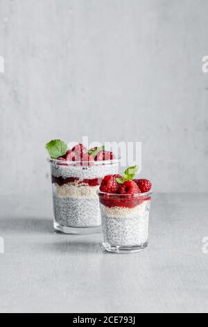 Von oben aus Glas mit leckeren Pudding mit gemacht gefüllt Joghurt Himbeeren Marmelade und Chiasamen Stockfoto