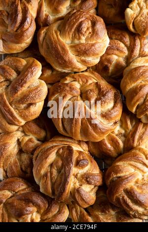 Von oben der Vollbildhintergrund der Haufen von köstlichen Zimtschnecken in der Bäckerei Stockfoto