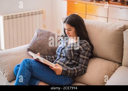 Junge Frau mit Buch zu Hause Stockfoto