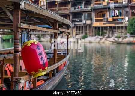 Rote Laterne auf dem alten Holzboot, das auf Tuo festgemacht ist Flussufer in Fenghuang Stockfoto