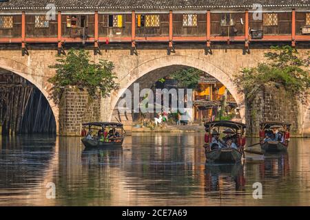 Touristenboote unter Bogenbrücke in der Feng huang Altstadt Stockfoto