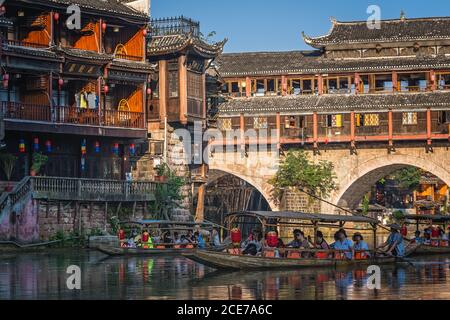 Touristenboote unter Bogenbrücke in der Feng huang Altstadt Stockfoto