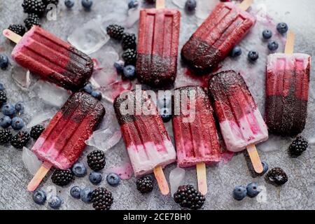 Hausgemachtes Brombeere- und Speiseeis oder Eis mit gefrorenen Beeren auf schwarzem Schiefertablett Stockfoto