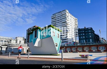 Brighton UK 31. August 2020 - EIN Läufer kommt an einem schönen sonnigen Morgen am Upside Down House an der Strandpromenade von Brighton vorbei, um den August-Feiertag Montag zu beginnen. Die Prognose ist für sie viel kühler als normal in einigen Teilen von Großbritannien heute : Credit Simon Dack / Alamy Live News Stockfoto