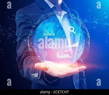 Globales Business Data Management. Businessman Holding Globe Hologramm Mit Grafiken Und Charts Stockfoto