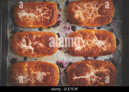 Köstliche heiße hausgemachte Brötchen gefüllt mit Heidelbeere auf einem Backblech Stockfoto