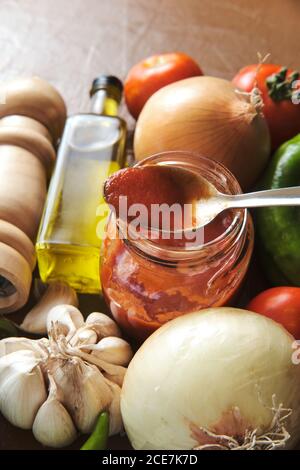 Draufsicht Komposition mit Tomatensauce im Glas inmitten platziert Frisches Gemüse und Olivenöl mit Gewürzen zum Kochen zubereitet Bolognese-Sauce Stockfoto