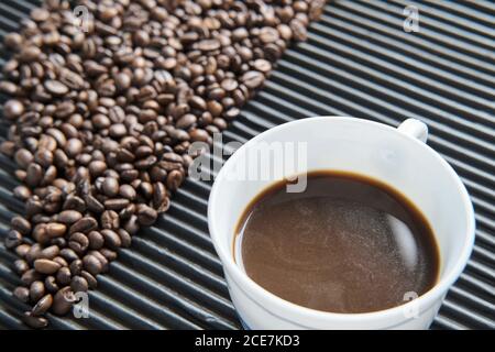 Tasse Kaffee und Körner Kaffee auf dem Tisch Stockfoto