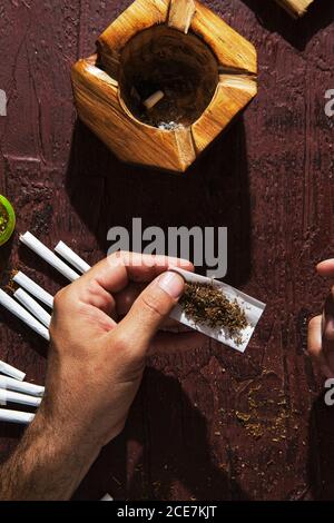 Unkenntlich männlicher Raucher, der Marihuana Joint macht Stockfoto