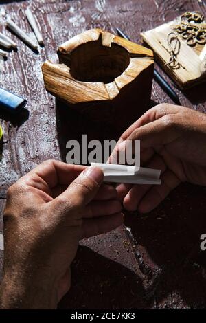 Unkenntlich männlicher Raucher, der Marihuana Joint macht Stockfoto