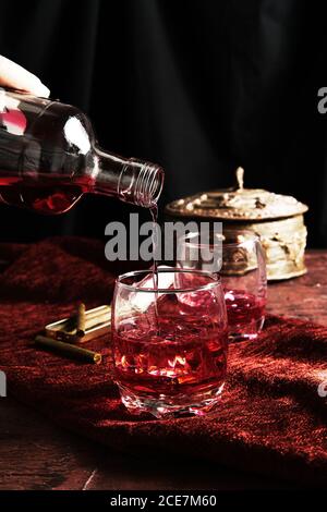 Anonyme Person serviert Whiskey in einem Glas Stockfoto