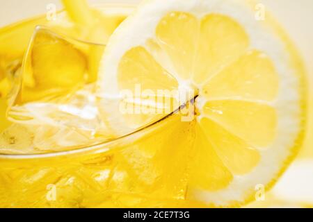 Von oben Ernte Detail des Glases des frischen Getränks mit Zitronen und Kiwi auf gelbem Hintergrund im Studio platziert Stockfoto