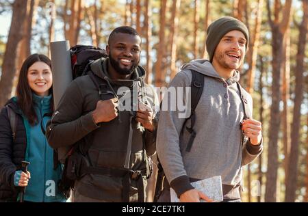 Internationale Gruppe von Rucksacktouristen geht durch Wald Stockfoto