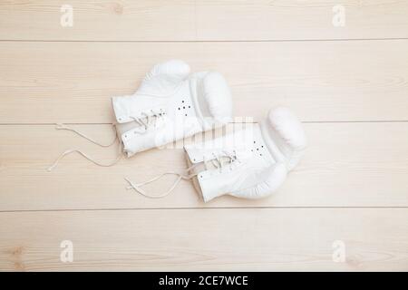 Weiße Boxhandschuhe auf Holzboden Stockfoto