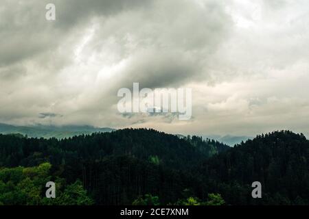 Herrliche Aussicht auf friedliche grüne Hügel unter bewölktem Himmel Mit dicken grauen Wolken in Transilvania Rumänien Stockfoto