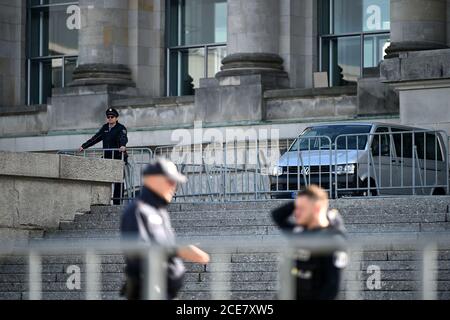 Berlin, Deutschland. August 2020. Drei Polizisten stehen vor dem Reichstagsgebäude. Zwei Tage zuvor stürmten Demonstranten mit Reichsflaggen und rechtsextremistischen Schimpfungen auf die Treppe des Reichstags, und nur drei Polizisten hielten die erzürnte Menge mit winkenden Knüppeln fern. Quelle: Johannes Neudecker/dpa/Alamy Live News Stockfoto