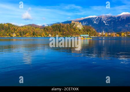 Panorama des Bleder Sees Blejsko Jezero, Slowenen mit Boot und Herbst bunten Julischen Alpen im Hintergrund Stockfoto