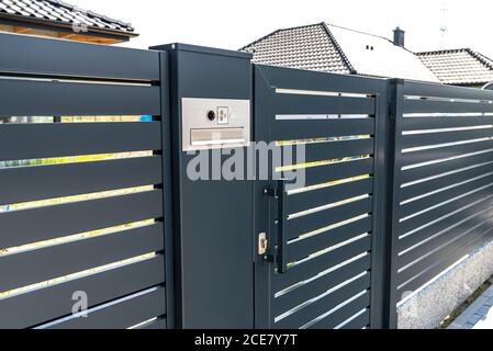 Ein modernes Videotelefon mit Briefkasten und kabellosem Kartenleser, montiert in anthrazitfarbenem Paneelzaun, sichtbares Wicket. Stockfoto