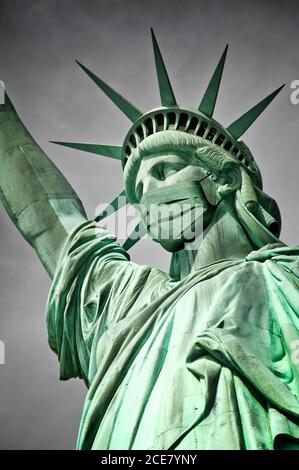 Die Freiheitsstatue trägt eine Maske. Coronavirus, Covid-19 Ausbruch in New York und USA Konzept Stockfoto
