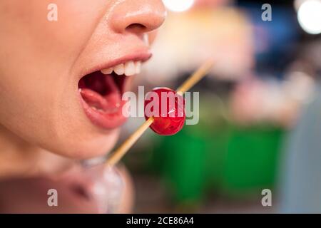 Hispanische Juwelierin sitzt am Tisch und versucht an Ringen, die in der Licht-Werkstatt auf weißer Plakette angebracht sind Stockfoto