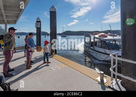 Ein Wassertaxi nähert sich einem Kai auf Dangar Island, um eine Familie zurück nach Brooklyn New South Wales, Australien zu transportieren Stockfoto