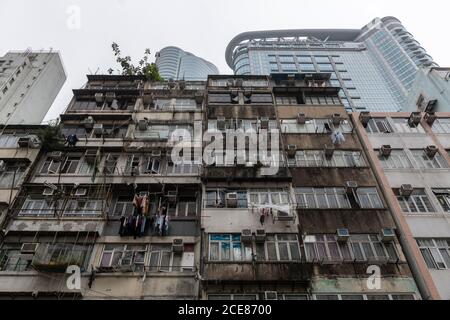 Hongkong, China: 12. März 2020. Altmodische Hong Kong-Gehäuse in Canton Road Mong Kok vor dem Hintergrund des modernen Cordis Hotel Building gesehen. A Stockfoto